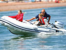 Three people in a fast boat on a lake 